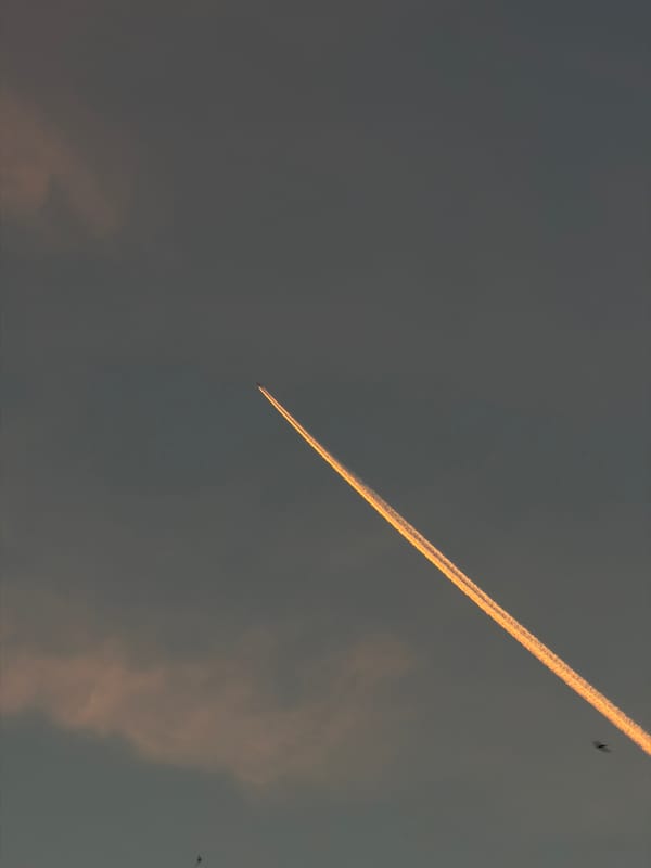 Sunset contrail glows golden against dark skies over Gorzów