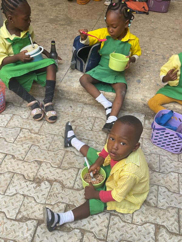 Schoolchildren share outdoor lunch break in Akwanga, Nigeria