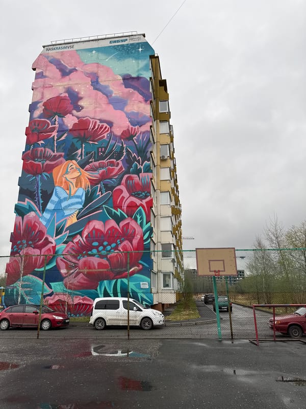 Child plays near floral mural on rainy day in Tobolsk
