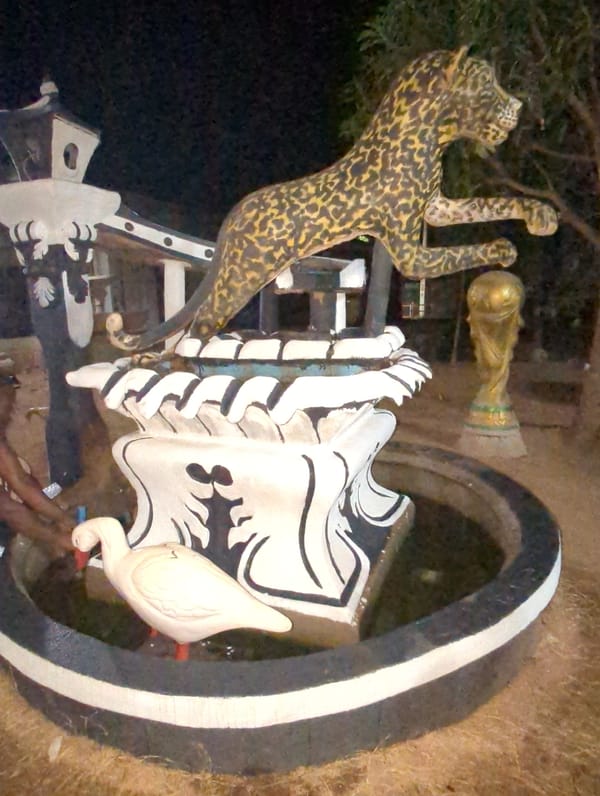 Man poses with leopard sculpture and World Cup trophy replica in Nigeria