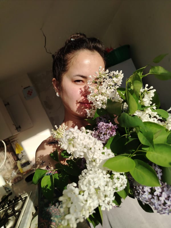 Woman with lilac bouquet observed in Noviy kitchen