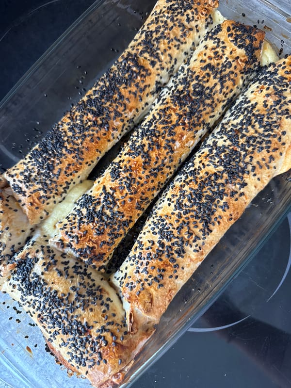 Fresh sesame-topped pastry rolls baked in glass dish