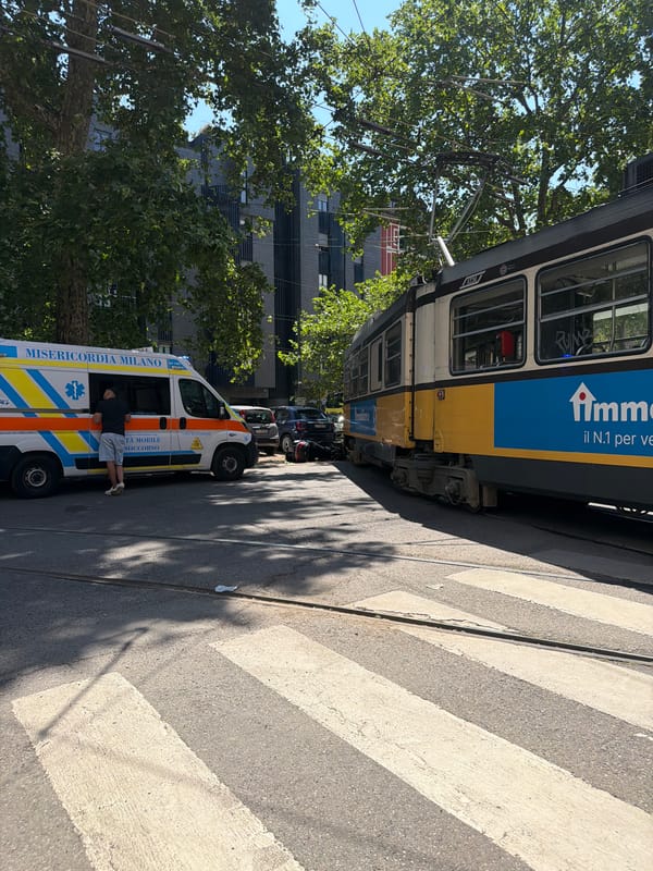 Milan ambulance responds near tram stop during sunny morning