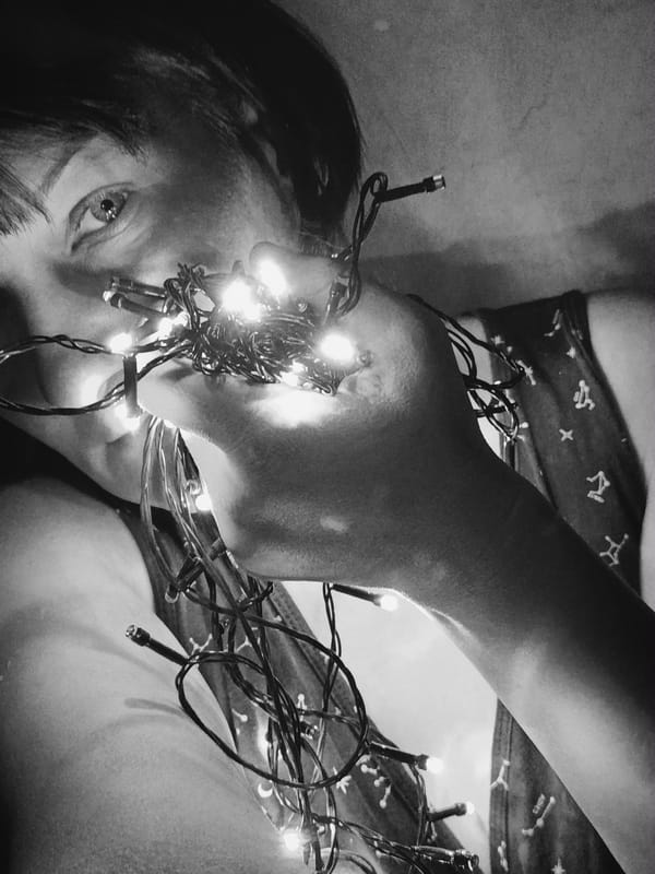 Person untangles Christmas lights indoors in early morning