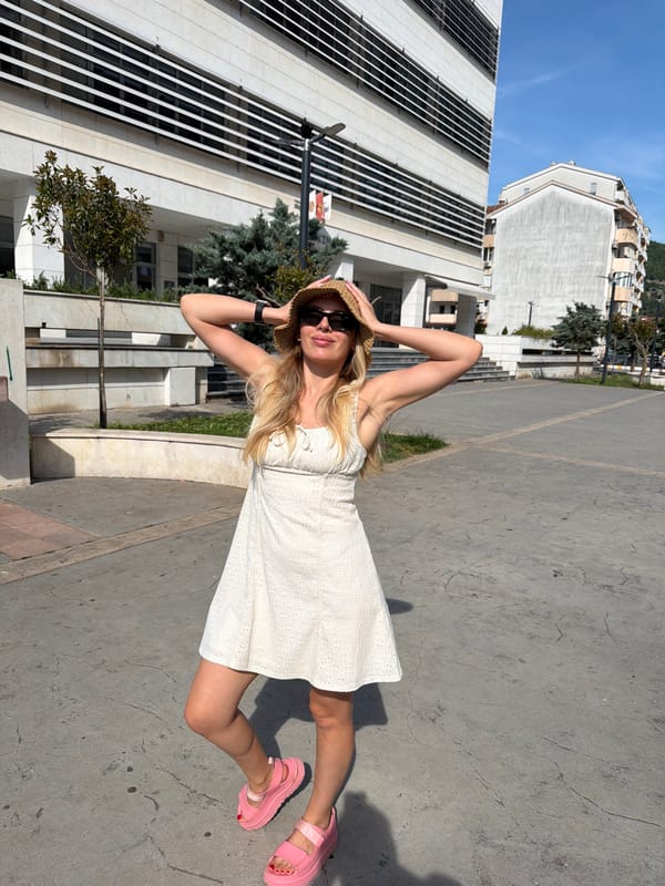 Tourist in white dress explores Budva streets over afternoon