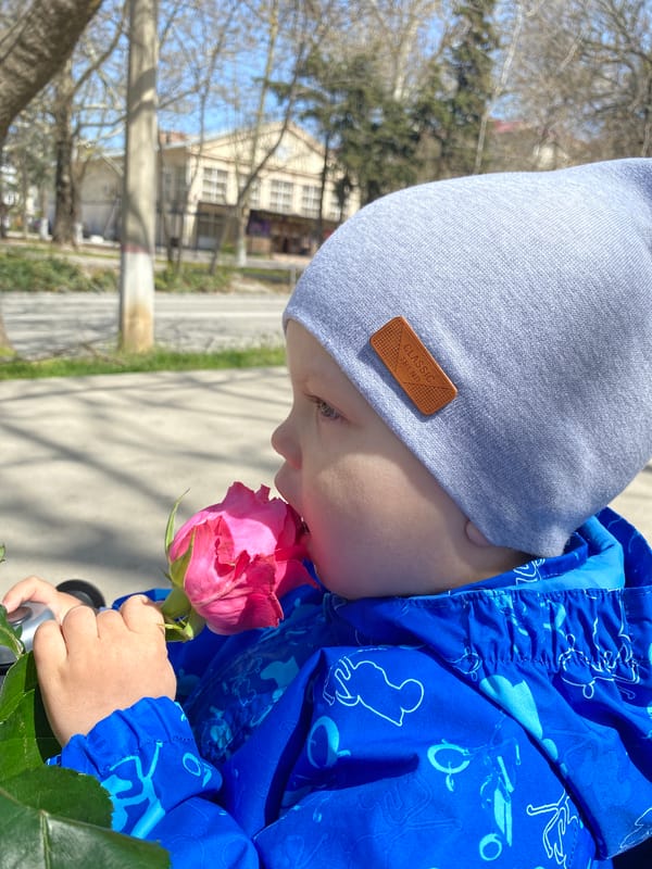 Child enjoys pink rose on Sevastopol sidewalk