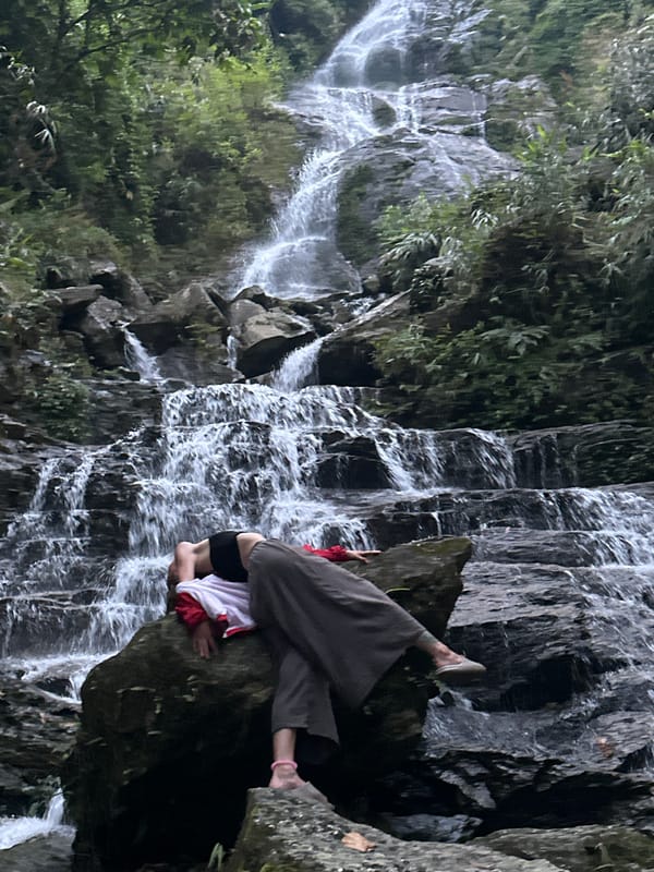 Woman poses at waterfall in Vietnam commune