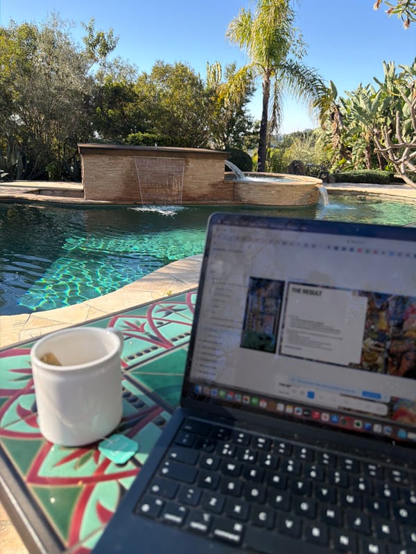Laptop setup observed poolside amid palm trees in Los Angeles