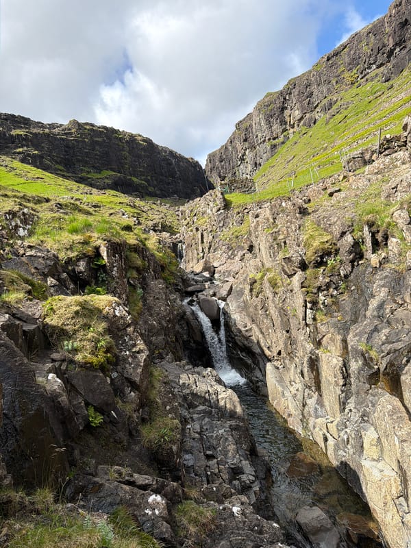 Waterfall and rugged ravine landscape near Haldórsvík, Faroe Islands