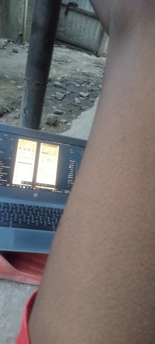 Person works on laptop outdoors in Yelwa, Nigeria