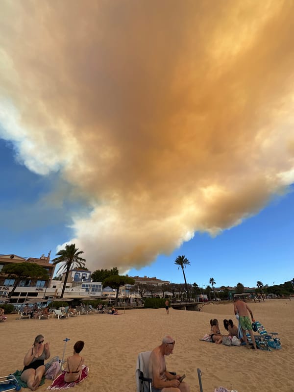 Wildfire smoke blankets Sant Feliu de Guíxols beach on a summer morning