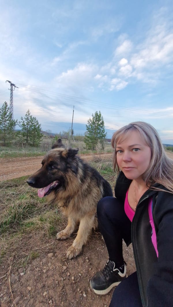 Woman walks German Shepherd on rural road near Otchor