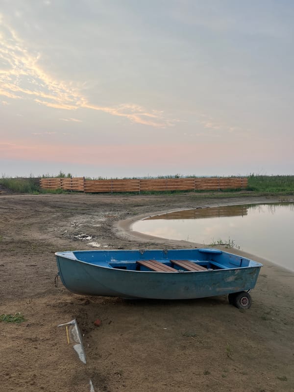 Boats at the waterfront as the sun sets over Novopichugovo