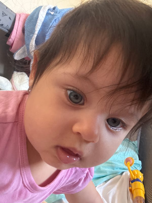Baby girl enjoys snack time in stroller in Lincoln