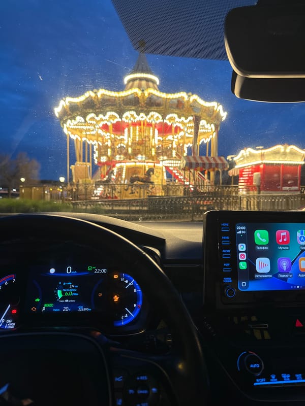 Parked outside a glowing carousel in Gdańsk at night