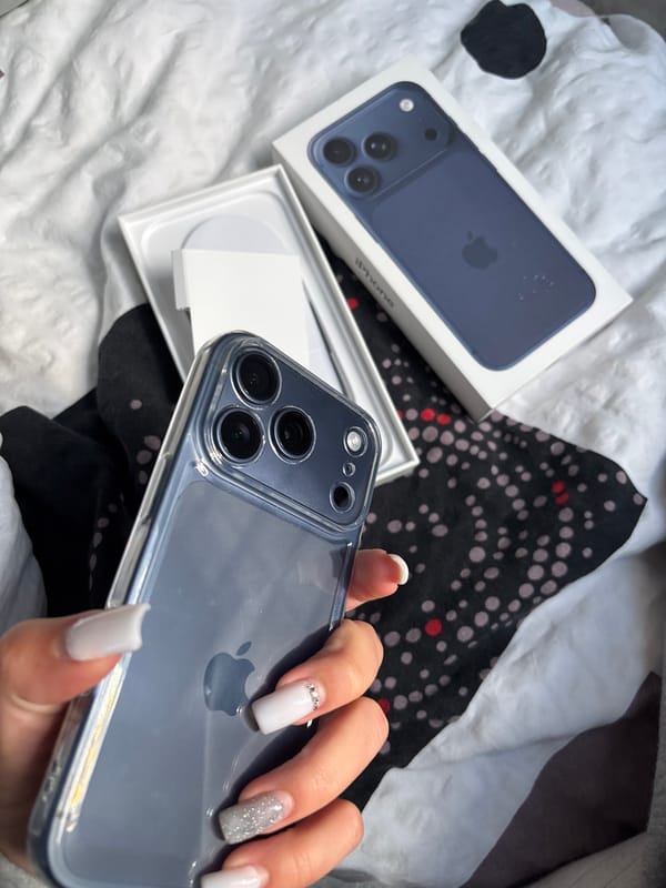 Person displays new blue iPhone with packaging in bedroom