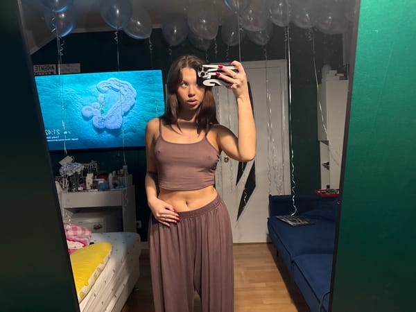 Person takes mirror selfie in brown outfit with balloons