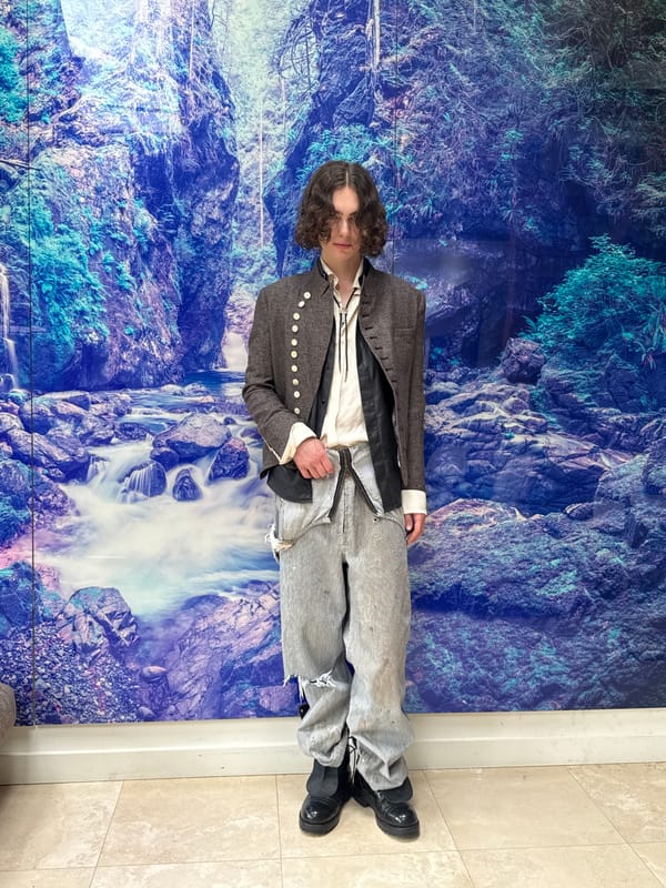 Person poses for photos against waterfall mural indoors