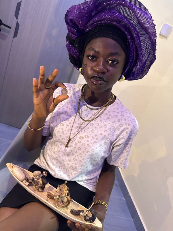 Person in traditional dress poses with miniature objects in Nigeria