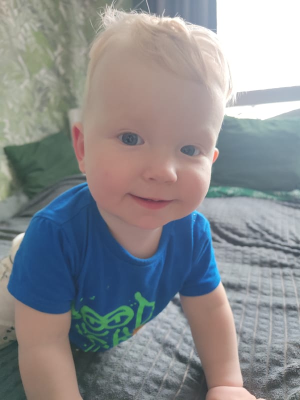 Young child rests on bed in Kuyeda, Russia