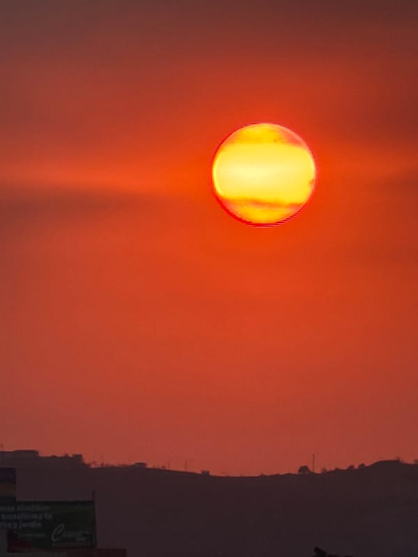 Sunset captured over Mexican town with volcanic mountain backdrop