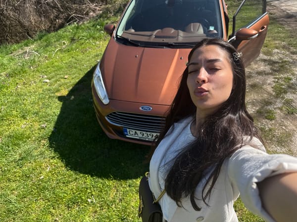Woman takes selfie beside Ford Fiesta in Bulgarian village