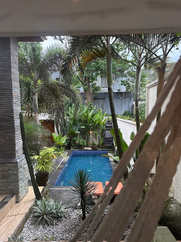 Tropical garden pool area observed from balcony in Kuta Selatan