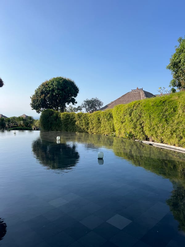 Morning at a Bali clifftop resort, pools, gamelan, and garden walks