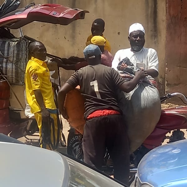 Men gather with loaded motorbikes, car in Dadi Riba