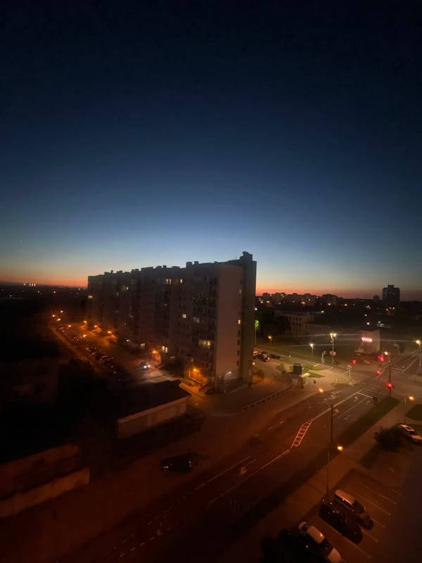Minsk residential skyline at dusk, crescent moon overhead
