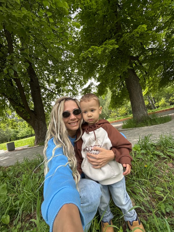 Woman and child rest in grass in Шебунино, Russia
