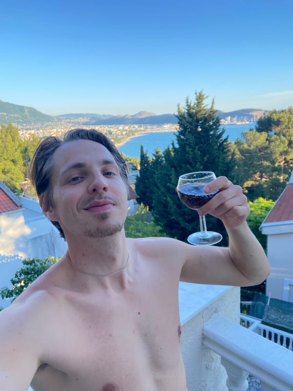 Man pours dark soda into wine glass on Montenegro balcony