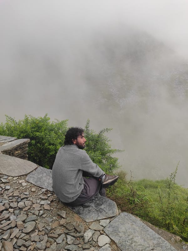 Sitting on a rocky ledge, gazing into fog