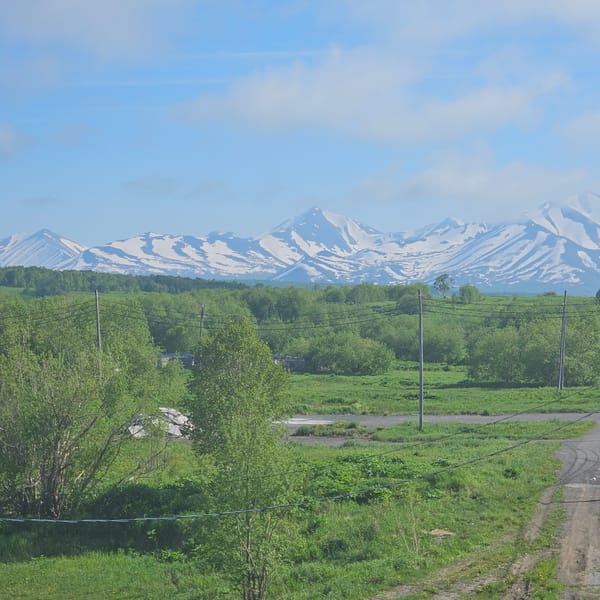 Snow-capped peaks and green fields outside Sokoch, Russia