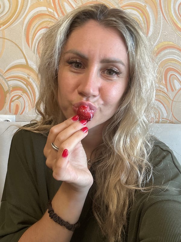 Fresh strawberries with cream, eaten and shown up close