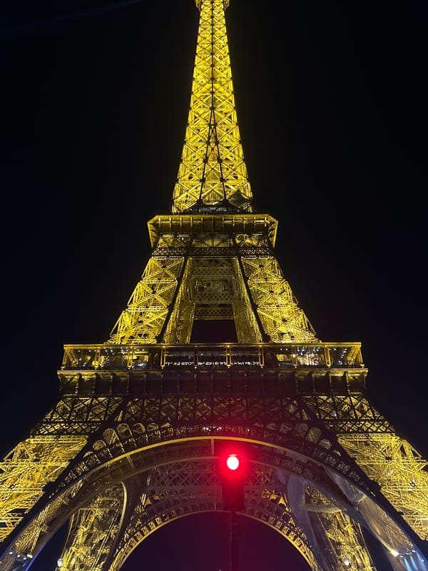Eiffel Tower glows yellow in Paris evening darkness