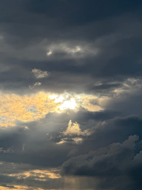 Backyard fire and storm clouds over rural Belarus