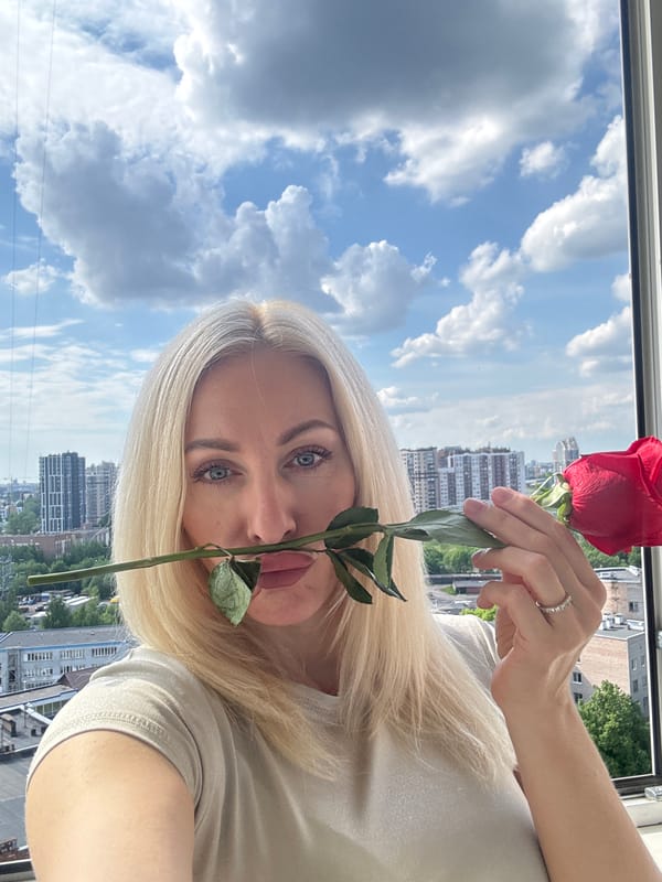 Woman with red rose photographed in urban setting