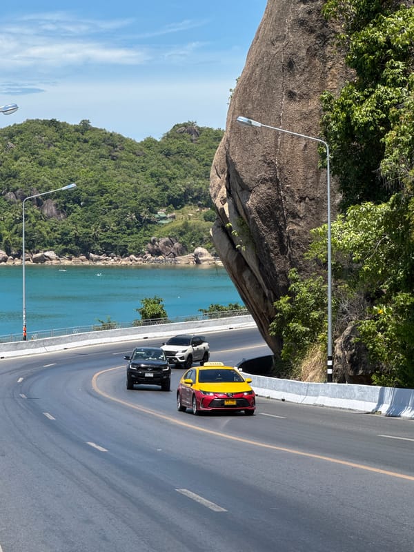 Cruising Ko Samui's scenic coastal road past boulder and bay