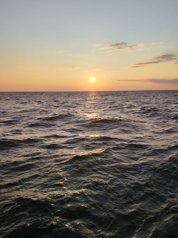 Golden sun low over calm Russian waters at dusk