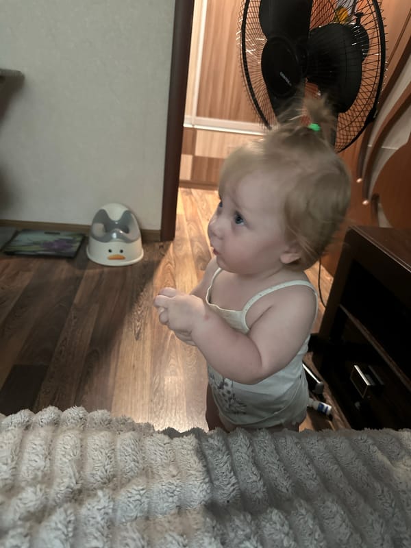 Toddler and poodle share a lazy morning at home in Sayanogorsk