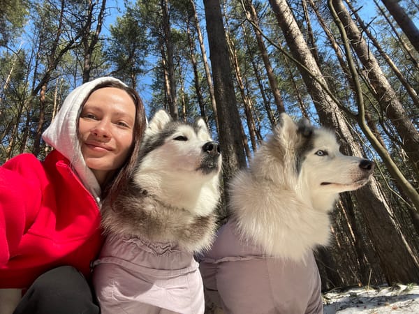 Woman walks husky in snowy Russian forest