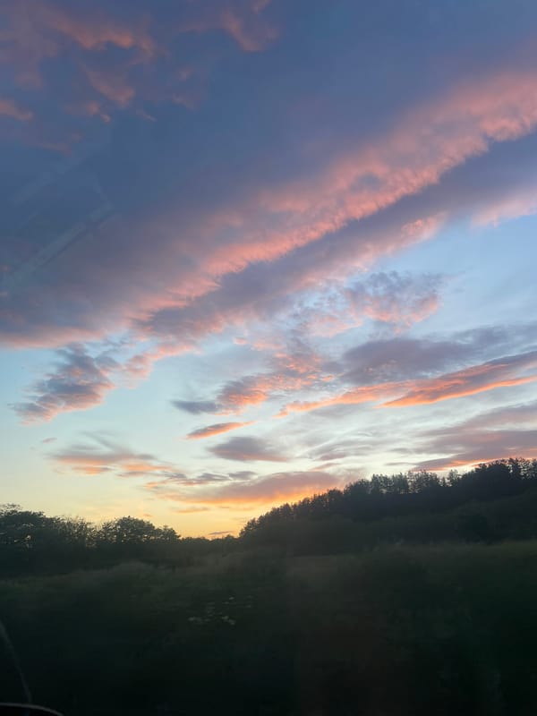 Sunset displays pink orange clouds over Kalofer Bulgaria