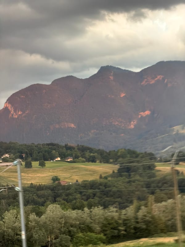 Sunset light over tree-covered mountains near Groisy, France