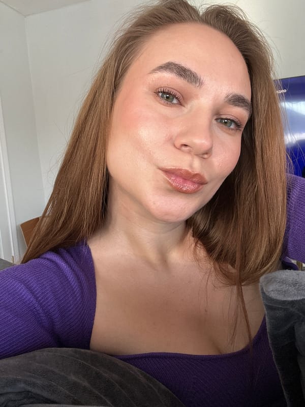 Woman poses for camera in purple top in Russian home