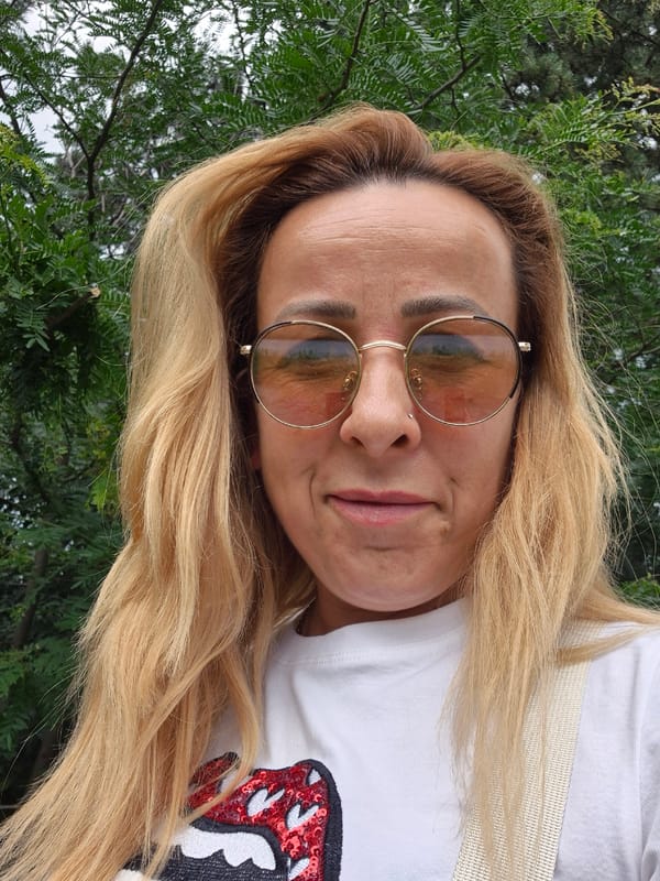 Woman photographs herself amid urban flowers and greenery