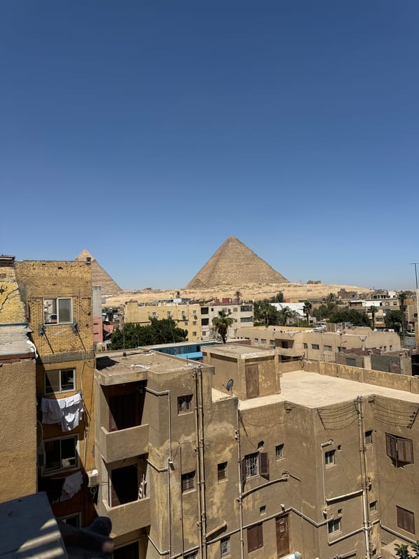 Rooftop view captures Giza pyramids against clear morning sky