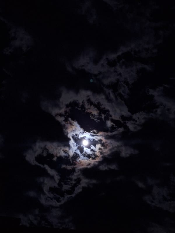 Dramatic moonlit sky observed through clouds over Bulgarian town