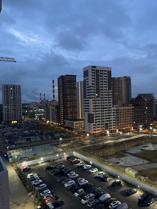 Moscow outskirts at twilight, parking lot and urban sprawl below