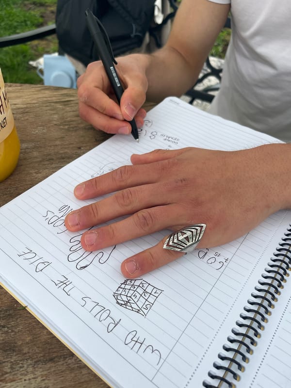 Writer sketches dice game notes beside blooming rose in Varna